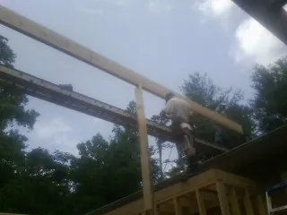 Carpenter setting a ridge beam over a new addition frame — Ice Dam Removal by Roofing Brothers in East Liberty