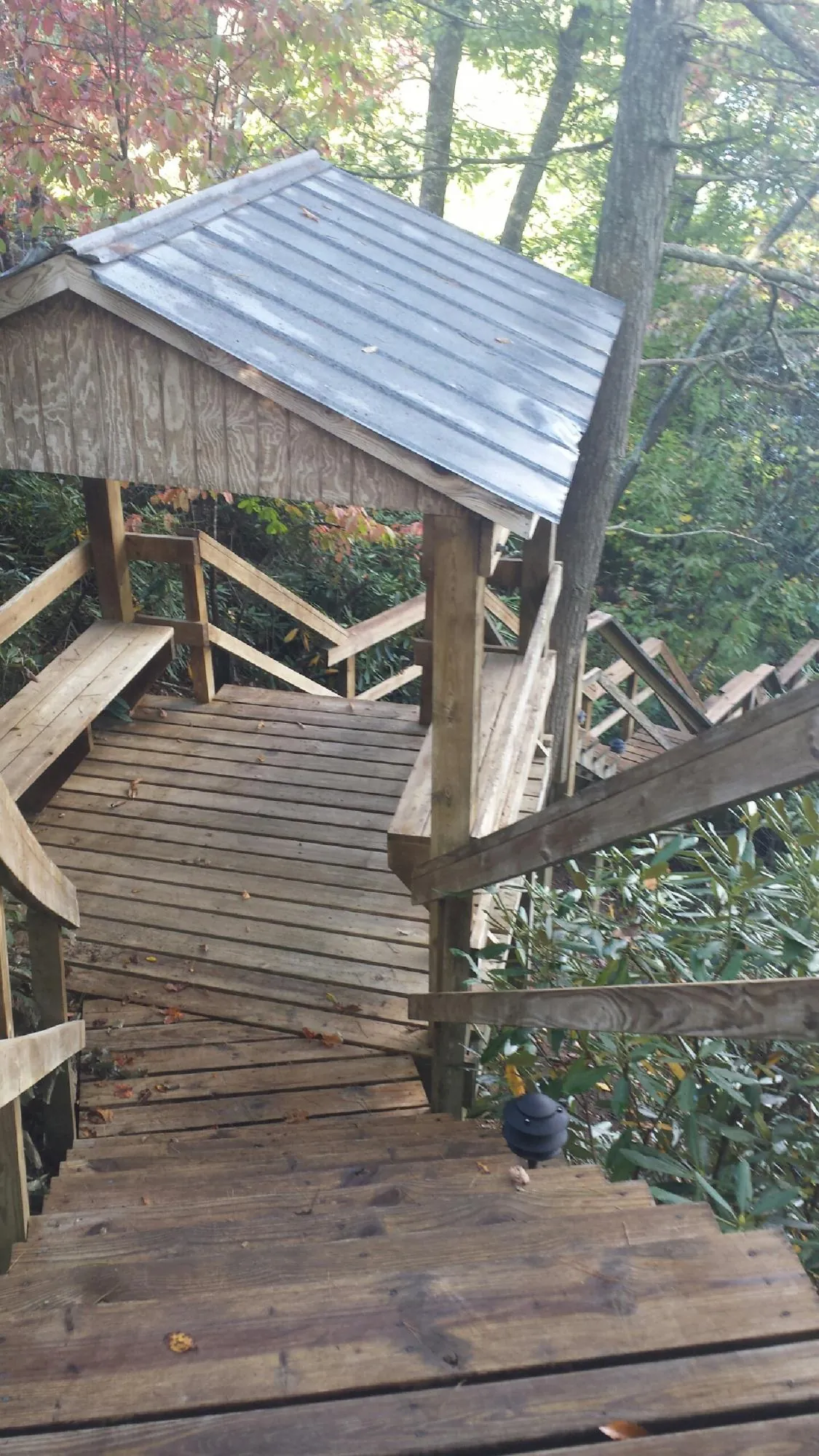 Metal roofed shelter over wooden steps on a wooded walkway — Skylight Repair & Installation work by our crew in East Liberty