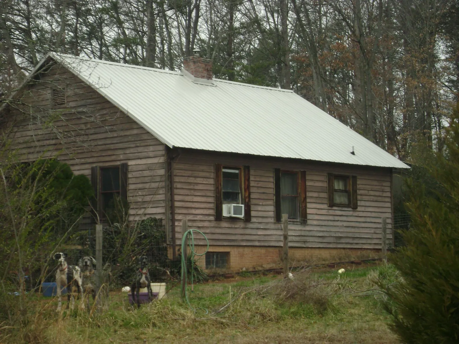 White metal roof on an old wood sided farmhouse, from a Metal Roof Installation job in East Liberty